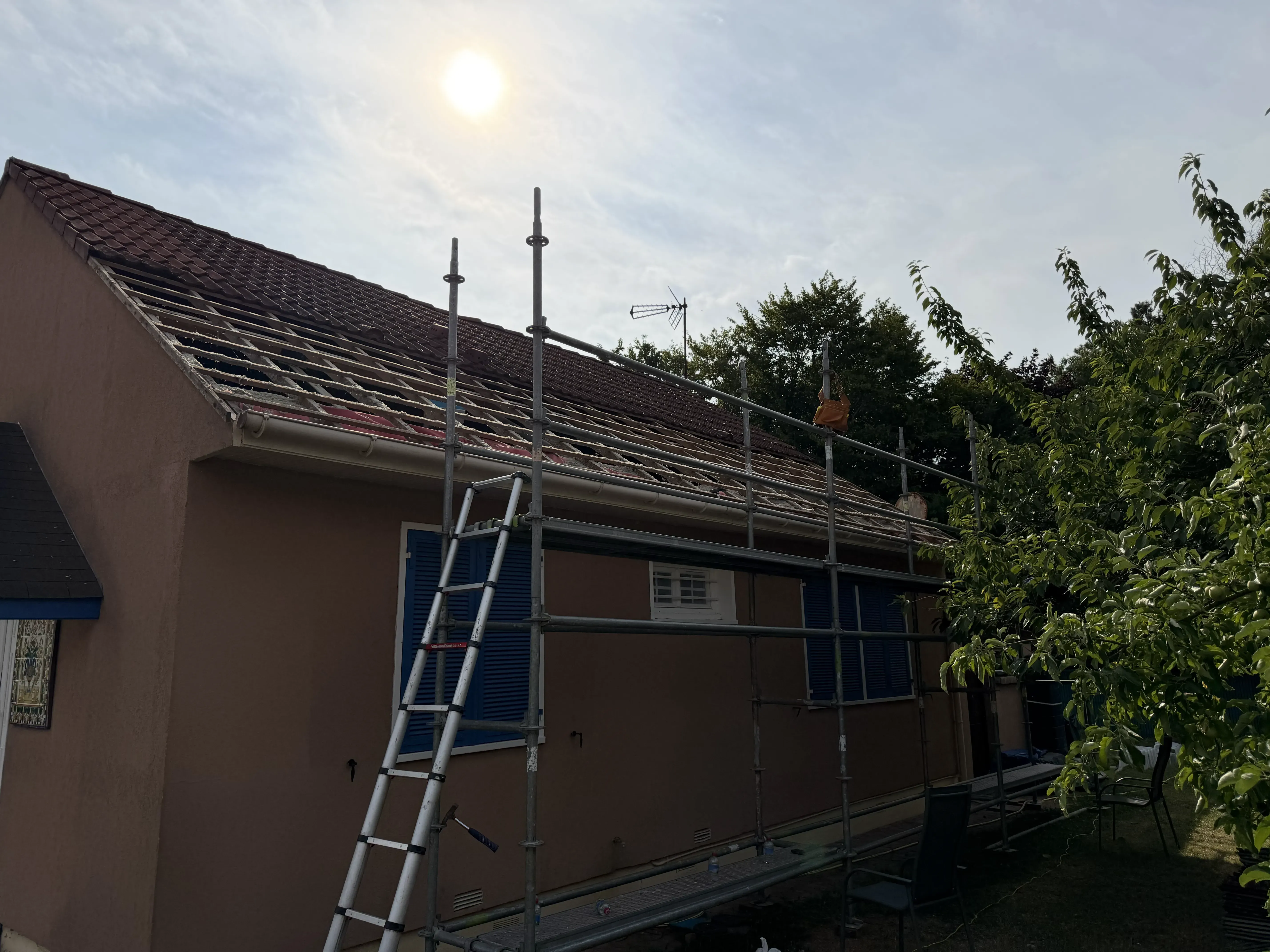 Dépose des anciennes tuiles en cours sur une toiture à Rambouillet, avant réfection complète