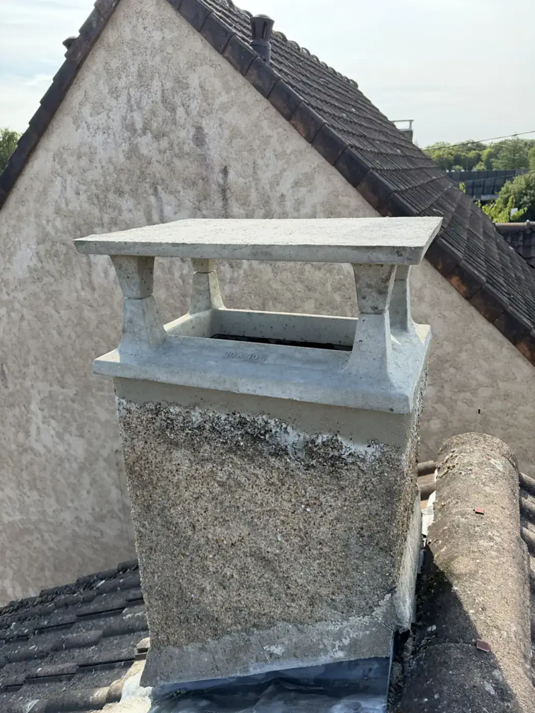 Chapeau de cheminée en béton posé sur une souche à Rambouillet par Moïse Fortin, août 2026