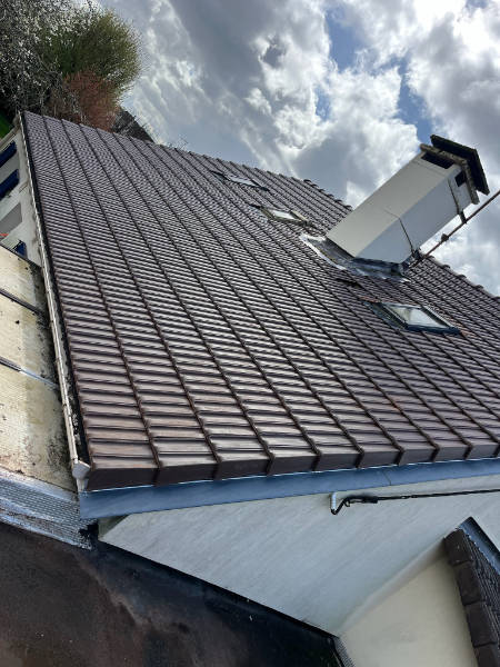 Vu transverse sur un chantier de rénovation terminé réalisé par Monsieur Fortin dans les Yvelines. On peut voir un pied de cheminée parfaitement étanche ainsi que trois fenêtres de toi sur une toiture neuve.