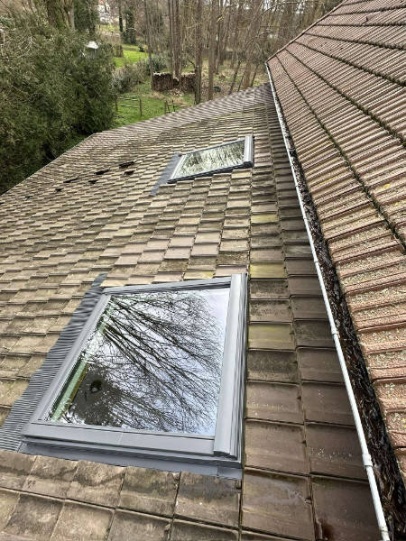 Gros plan sur deux fenêtres de toit qui ont été installées à l'arrière d'une toiture dans les Yvelines. Il s'agit de fenêtre de toi récente moderne qui améliore considère Ables ment la luminosité de votre pièce située sous sous l'apprenti.