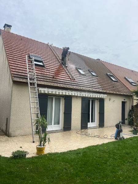 Artisan en train d'effectuer un nettoyage de toiture dans les Yvelines