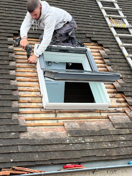 Installation d'une fenêtre de toit sur une toiture dans les Yvelines, toiture en tuiles plates vue sur les chevrons et installation, installation du kit d'étanchéité par Monsieur Moïse Fortin